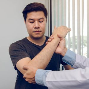 Asian Physiotherapists Check The Elbows Of Patients Who Have Und Asian physiotherapists check the elbows of patients who have undergone orthopedic rehabilitation.